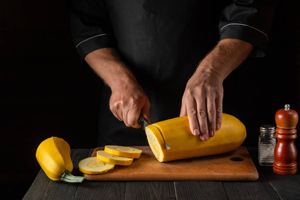The chef cuts ripe yellow marrow with a knife. Fried zucchini is a great diet for breakfast or lunch. Work environment on the kitchen table of the restaurant. Free advertising space. - Photo, Image