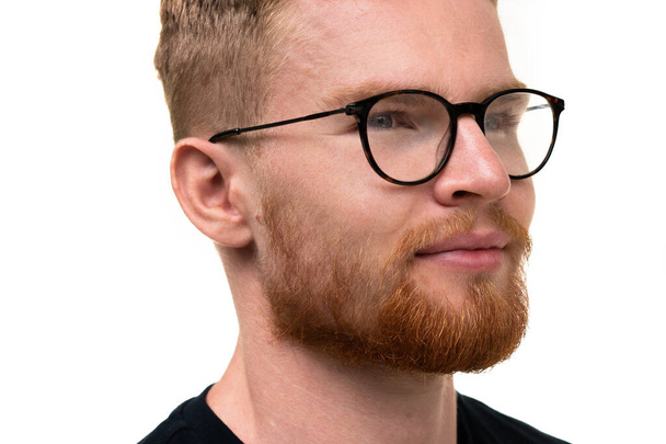 Een portret van een aantrekkelijke jongeman met een bril op een witte achtergrond. - Foto, afbeelding