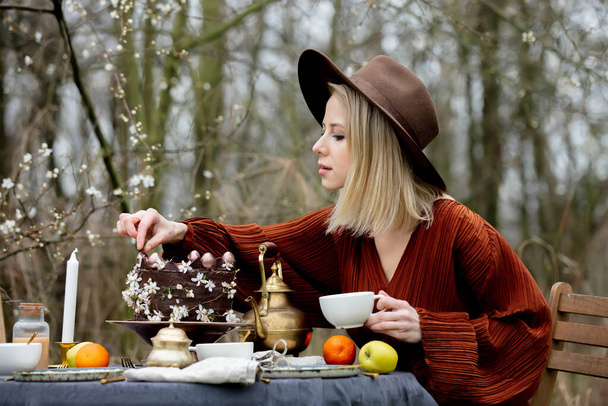 Hermosa mujer bebiendo un té en un jardín  - Foto, Imagen