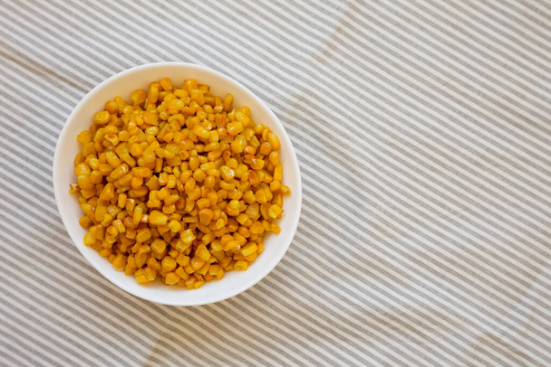 Maïs doux rôti jaune dans un bol blanc, vue de dessus. Couché à plat, au-dessus, par le haut. Espace pour le texte. - Photo, image