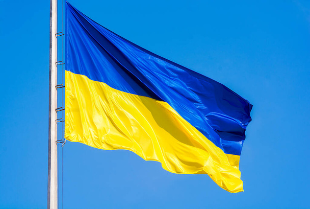 Bandera ucraniana contra un cielo azul. Colores amarillo y azul. Símbolo nacional de Ucrania. - Foto, Imagen