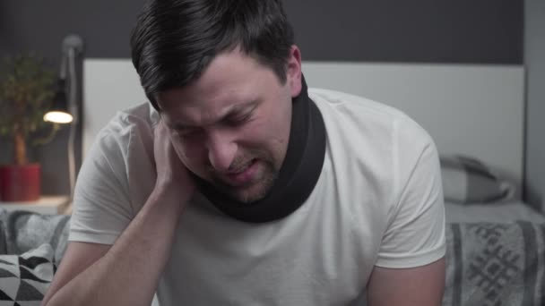 Behinderter schmerzhafter Mann mit Nackenstütze, der zu Hause telefoniert. Mann mit Wirbelsäulentrauma im Halswirbelsäulenbereich ruft Versicherung um medizinische Hilfe. Mann mit Nackenverletzung ruft nach Unfall Arzt - Filmmaterial, Video