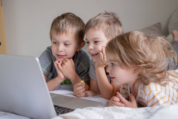 Little kids having video chat via laptop at home lifestyle - Fotó, kép