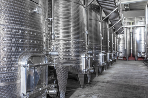 ワイナリーでのワイン発酵のためのスチールワインタンク。発酵のためのタンクが大きい近代的なワイン工場. - 写真・画像