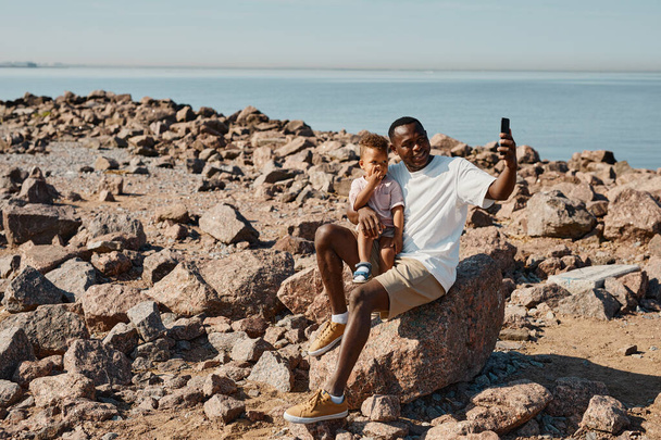 Padre e hijo tomando selfie en playa - Foto, imagen