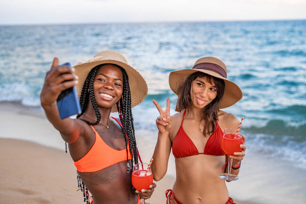 Girlfriends taking funny selfie on beach - Fotó, kép