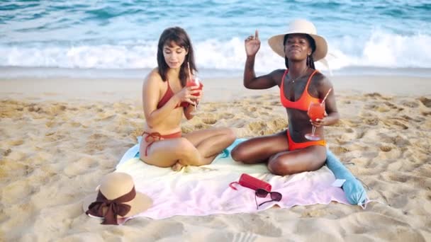 Two best multiracial friends sitting on summer beach - Footage, Video
