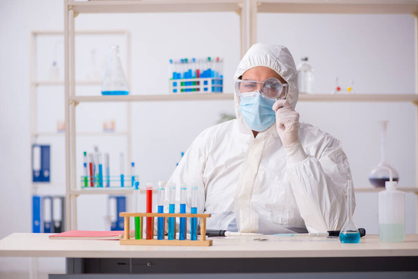 Молодой химик работает в лаборатории во время пандемии - Фото, изображение