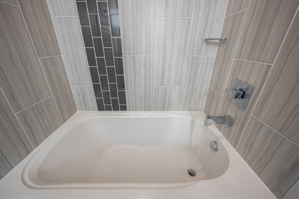Modern fürdőkád csempézett háttámlával és vízfolyással - Fotó, kép