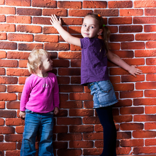 Children posing near the brick wall - Φωτογραφία, εικόνα