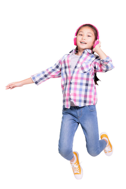 Gelukkig student meisje draagt koptelefoon en jumping.Isolated op witte achtergrond. - Foto, afbeelding