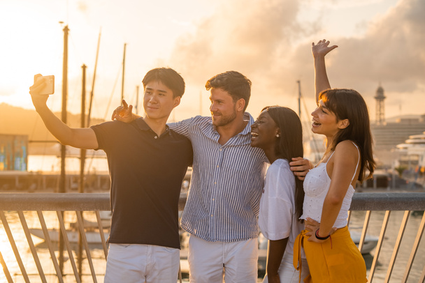 Amigos multirraciales tomando selfie en terraplén - Foto, Imagen