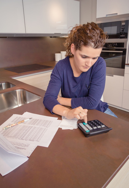 Mujer desempleada y divorciada con deudas revisando sus facturas mensuales
 - Foto, imagen