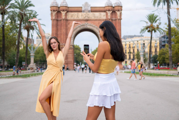 Счастливые туристки фотографируют на городской площади - Фото, изображение