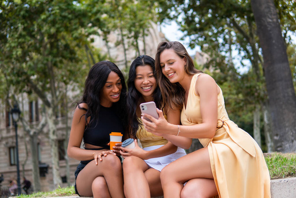Novias multiétnicas con smartphone y café en la ciudad - Foto, Imagen
