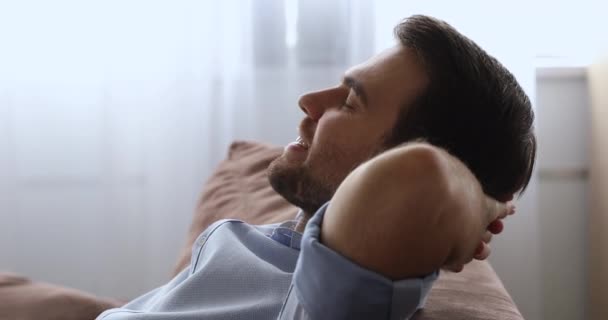 Mindful young male homeowner relaxing on comfortable couch. - Metraje, vídeo