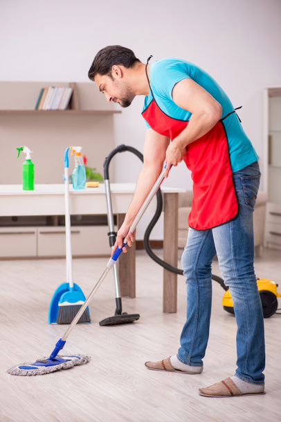 Joven contratista masculino limpiando la casa - Foto, imagen