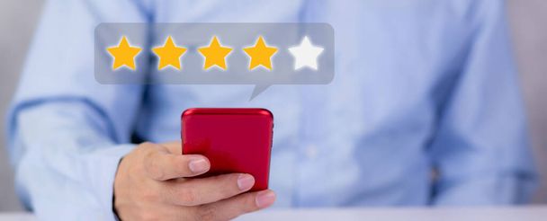 Customer holding phone and pressing star icon for vote score review and feedback with quality and satisfaction, success of digital marketing with result excellent for ranking of service. - Photo, Image