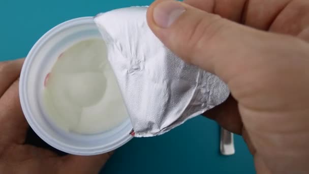 Yaourt ouvert à la main masculin méconnaissable dans une tasse en plastique - Séquence, vidéo