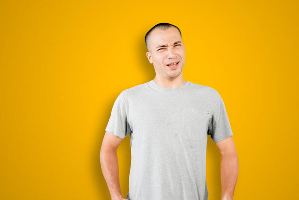 Image of Caucasian man standing with confused expression in the studio with yellow background - Foto, Bild