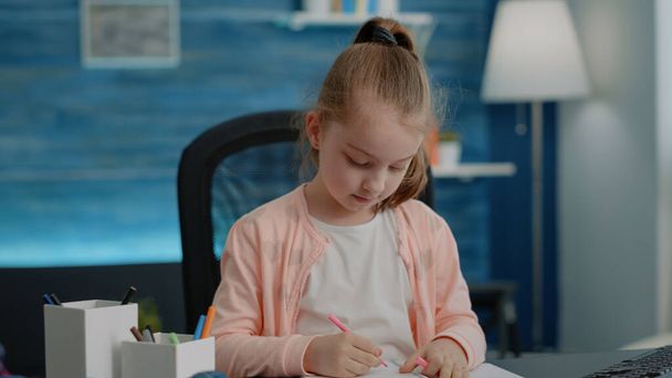 Közelkép iskolás lány segítségével tollak és ceruzák írni notebook - Fotó, kép