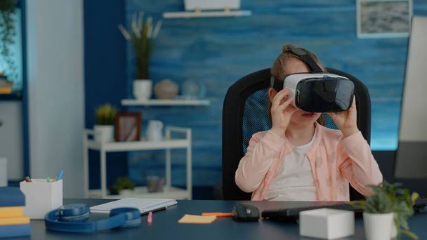 Okulda sanal gerçeklik egzersizi için VR gözlük takan genç bir kız. - Fotoğraf, Görsel