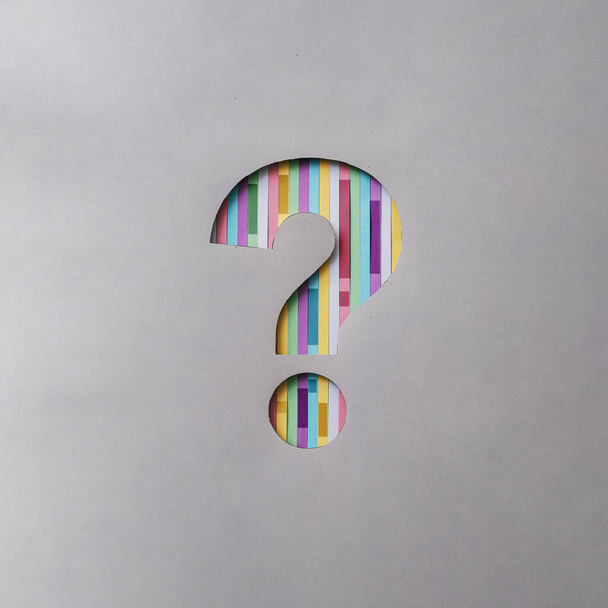 Creative symbol question mark cut out in a gray background with colored stripes concept of the idea of finding an answer and information, help, communication - Foto, afbeelding