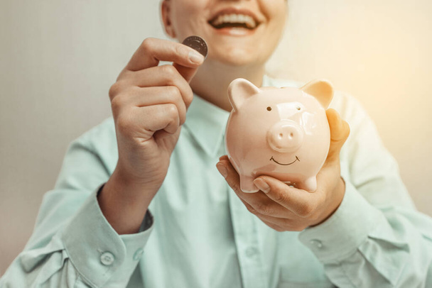 Щаслива жінка заощаджує гроші на скарбничці з щасливим обличчям, зберігає концепцію грошей
 - Фото, зображення