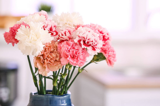 Vase with beautiful carnations in kitchen - Foto, afbeelding