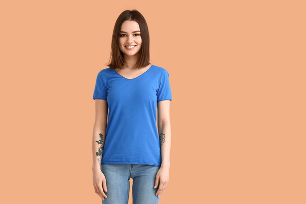 Jonge vrouw in modern t-shirt op kleur achtergrond - Foto, afbeelding