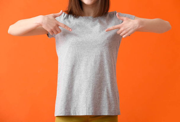 Mujer joven en camiseta moderna sobre fondo de color - Foto, imagen