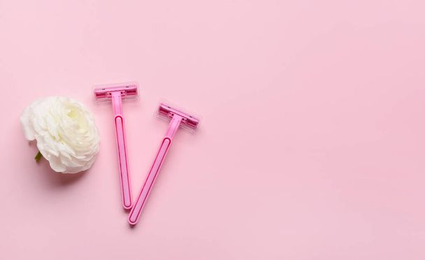 Navajas de afeitar de seguridad y flor sobre fondo rosa - Foto, imagen