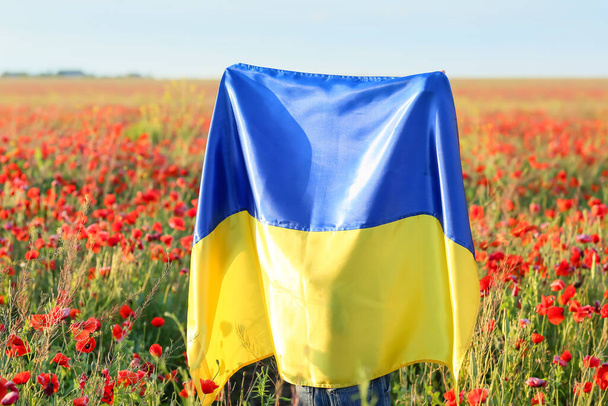 Little girl with Ukrainian flag in poppy field - Photo, Image