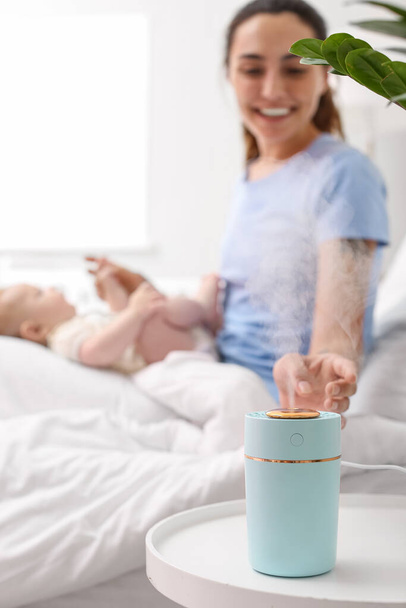 Äiti ja hänen vauva moderni ilmankostutin makuuhuoneessa - Valokuva, kuva