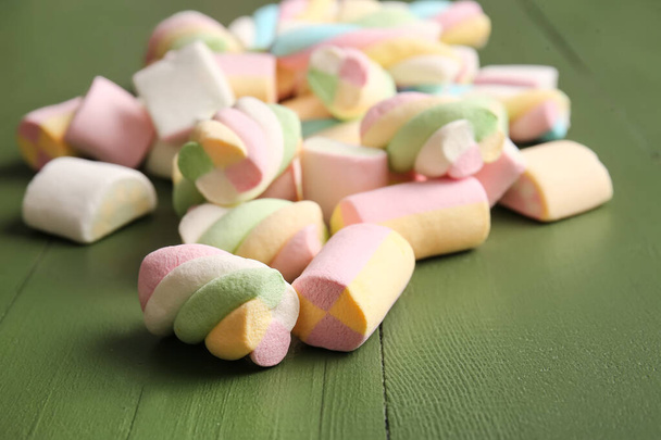 Zoete marshmallows op kleur houten achtergrond, close-up - Foto, afbeelding