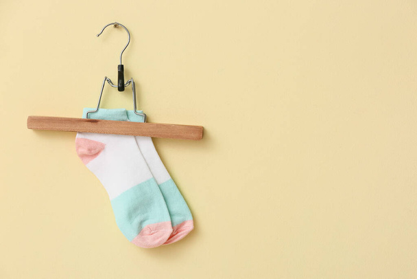 Hanger with pair of socks on color background - Photo, Image