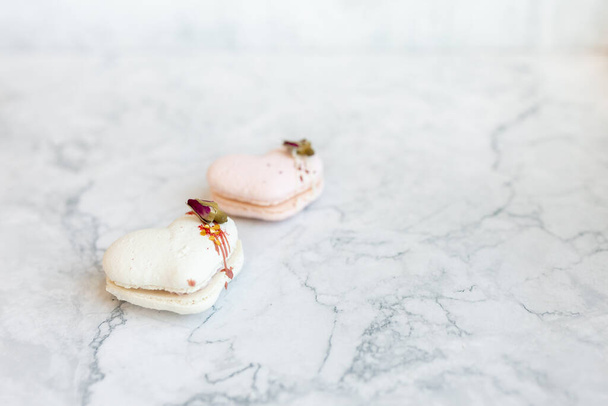 Macaroons close up. Pink and white macaroons on the murble table. Background for Valentine's Day - Fotografie, Obrázek