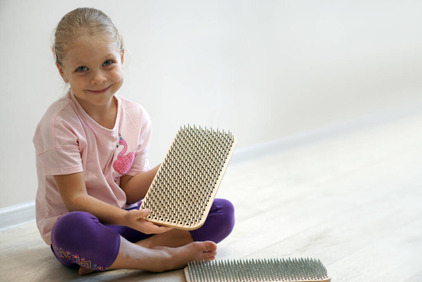 The sadhu's board is in the hands of a beautiful little yogini girl. Children's yoga, meditation and practice. - Foto, Bild