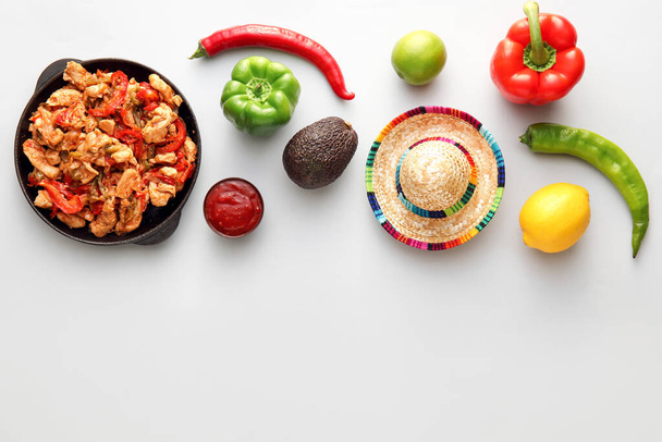 Composition with tasty Fajita, vegetables and sombrero hat on white background - Photo, Image