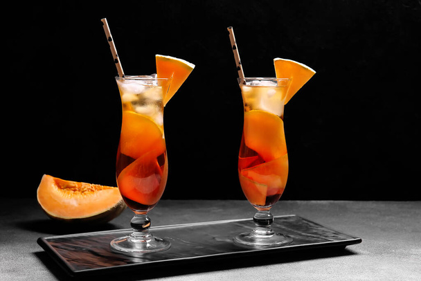 Доска с бокалами вкусного коктейля дыни на тёмном фоне - Фото, изображение