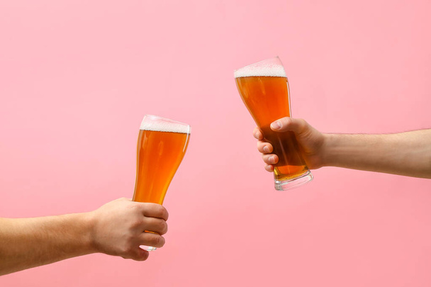 Ruce s sklenicemi piva na barevném pozadí - Fotografie, Obrázek