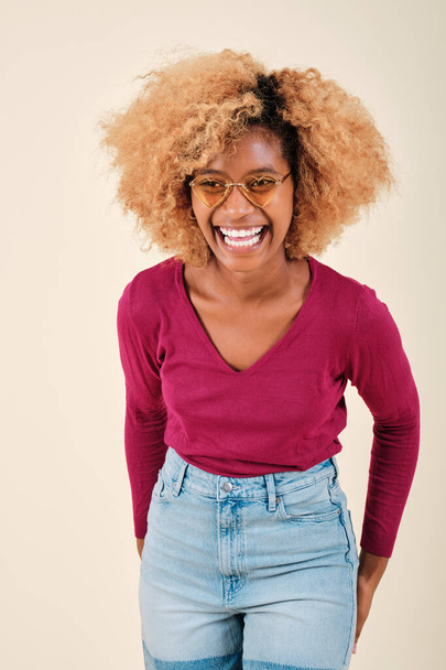 Happy and excited curly haired woman smiling while standing against an isolated background. - Photo, Image
