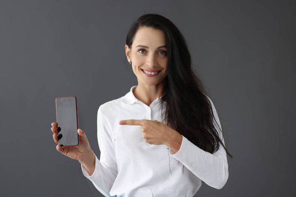 Ritratto sorridente di donna che tiene lo smartphone in mano - Foto, immagini