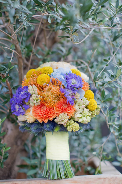 Jasny kolorowy bukiet ślubny z pomarańczowymi, żółtymi, białymi i niebieskimi kwiatami. Koncepcja ślubu na Sycylii - Zdjęcie, obraz
