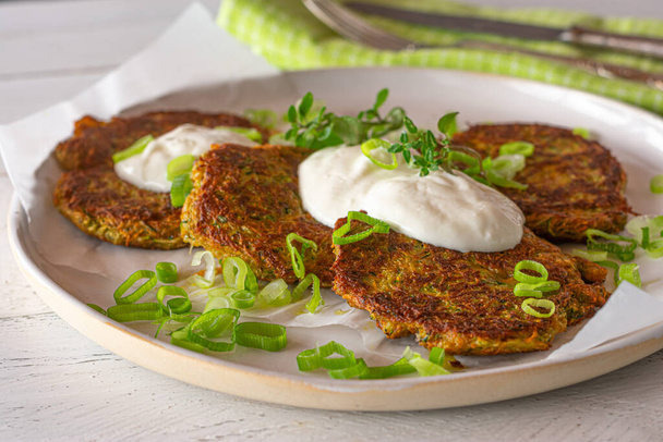Vegetable pancakes with dip. Homemade fresh fried vegetable pancakes fried with zucchini and carrots and served with a greek yogurt dip. Topped with chives and cress. Soft health food - Photo, Image