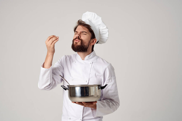 chef profesional con una cacerola tratando de comida  - Foto, Imagen