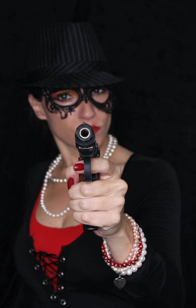 Жінка в масці з пістолетом Нехай DOF фокусується на стилі Гангстера 1920
 - Фото, зображення