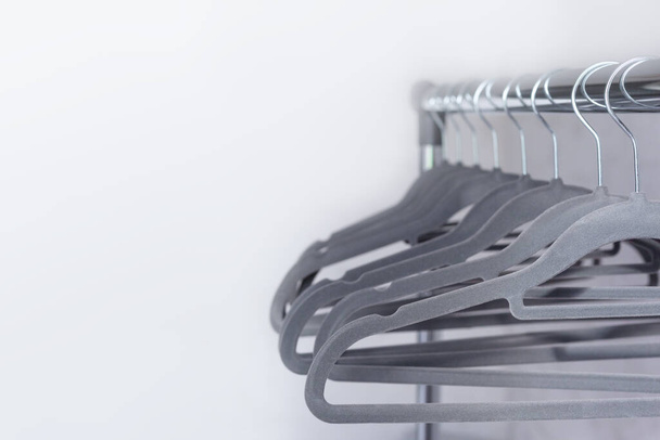 Modern velvet grey empty hangers on neutral wall background with copy space. - Photo, Image