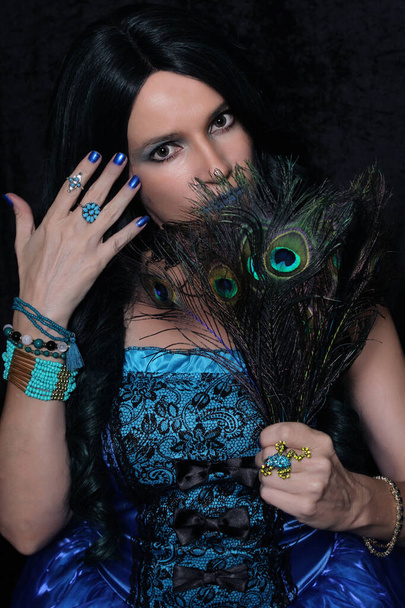 Vestido de mujer en corsé azul con pelo verde y negro y plumas de pavo real - Foto, imagen