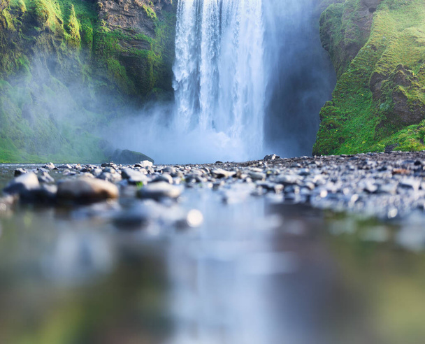 Водопад Скогафосс, Исландия. Горная долина и отражение на поверхности воды. Природный пейзаж в летний сезон. Исландская природа. Изображение - Фото, изображение